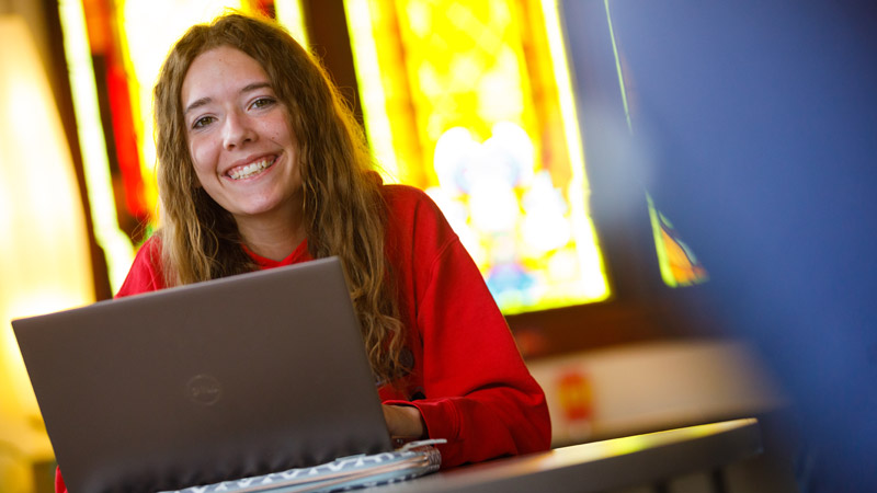Student smiling at computer